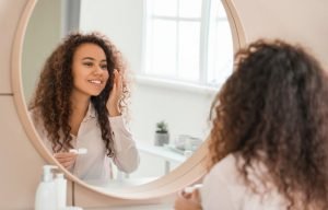curly hair girl putting on ortho k lenses How Do Ortho-K Lenses Work body ss
